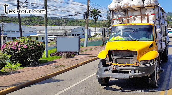 Неординарный разбитый желтый грузовик с тюками отельного белья